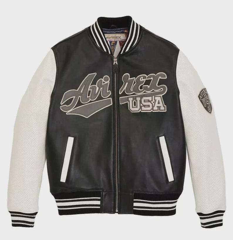 May include: Black leather bomber jacket with white perforated sleeves. The jacket features the text "Air Rex USA" on the chest and a patch on the right sleeve. The collar, cuffs, and hem have black and white striped detailing.