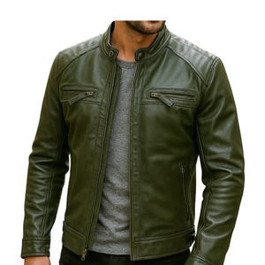 May include: An olive green jacket with a stand-up collar, a full-length front zipper, and two horizontal zippered chest pockets. The jacket features long sleeves with buttoned cuffs and a smooth, matte finish, worn over a gray shirt and black pants.
