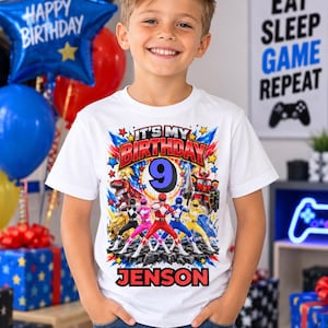 May include: A white short-sleeve t-shirt featuring a colourful graphic print of five Power Rangers characters, the text "IT'S MY BIRTHDAY", the number "9" in a blue circle, and the name "JENSON" in bold red letters at the bottom of the design.