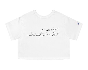 Peut inclure: Haut court blanc avec du texte en écriture manuscrite. Le t-shirt a des manches courtes et un logo Champion sur la manche gauche. Le texte est de couleur foncée et semble être dans une langue étrangère.