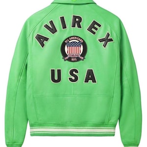 May include: A bright green leather jacket with the word "AVIREX" arched across the upper back. Below the brand name is a circular patch with the words "ALL AMERICANS" and "ESTABLISHED 1975" surrounding a US flag design. The word "USA" is printed below the patch.