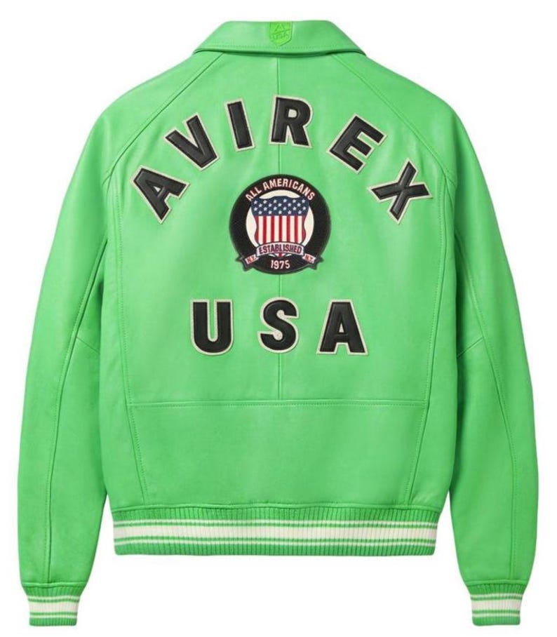 May include: A bright green leather jacket with the word "AVIREX" arched across the upper back. Below the brand name is a circular patch with the words "ALL AMERICANS" and "ESTABLISHED 1975" surrounding a US flag design. The word "USA" is printed below the patch.