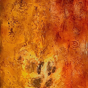 May include: Abstract painting with a textured surface. The artwork features a warm color palette of oranges, yellows, and browns, with a central area of lighter tones and darker accents. The piece has a rough, layered appearance.