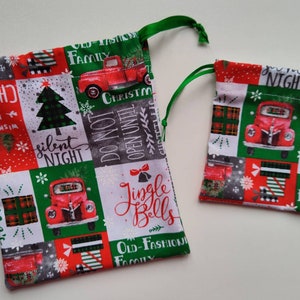 May include: Two red and green Christmas gift bags with a vintage truck and Christmas tree design. The larger bag has the text "Jingle Bells" and "Do Not Open Until Christmas". The smaller bag has the text "Silent Night".