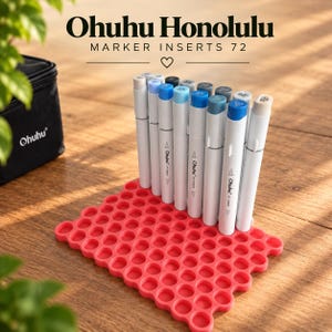 Op de afbeelding: Een set Ohuhu Honolulu marker-inzetstukken 72 met een rechthoekige, koraalkleurige siliconen rooster-organizer met meerdere ronde sleuven. Verschillende witte markers met blauwe en grijze doppen staan rechtop in het rooster naast een zwarte tas.