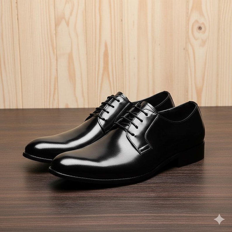 May include: A pair of black leather dress shoes with a glossy finish. The shoes feature a classic lace-up design and a low heel. The image shows the shoes from a side angle, highlighting their sleek and polished appearance. Suitable for formal occasions.