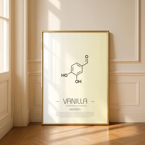May include: A framed print featuring the molecular structure of vanilla, with the word "VANILLA" in a minimalist font. The print has a gold frame and a cream-colored background. The scientific formula is in black.