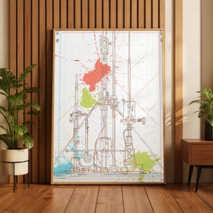 May include: A framed print featuring a detailed technical drawing in brown lines, overlaid with colorful paint splatters in red, green, and blue. The artwork is set against a grid background, creating a vintage aesthetic. The frame is a light brown color.