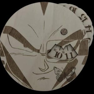 Puede incluir: Un reloj de madera con un diseño grabado con láser de la cara de un personaje, con una mariposa y la hora mostrada como 10:30 y 11:30. El reloj tiene un color de madera clara con detalles grabados más oscuros.