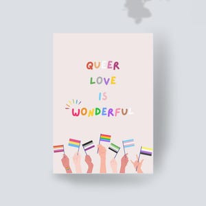 Könnte beinhalten: Eine rechteckige Grußkarte mit hellrosa Hintergrund und dem mehrfarbigen Text QUEER LOVE IS WONDERFUL. Unter dem Text sind mehrere erhobene Hände zu sehen, die jeweils eine kleine Flagge halten, die verschiedene Identitäten repräsentiert.