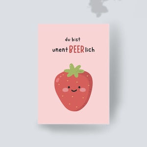 Puede incluir: Una tarjeta de felicitación rectangular con fondo rosa claro que presenta una fresa de dibujos animados con una cara sonriente y mejillas rosadas. El texto sobre la fresa dice "du bist" en negro y "unent BEER lich" con "BEER" en rojo.