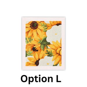 May include: A framed floral print featuring a vibrant arrangement of sunflowers and white flowers. The sunflowers are yellow with brown centers, and the white flowers have a textured appearance. Green leaves are interspersed throughout the design. The text "Option L" is at the bottom.