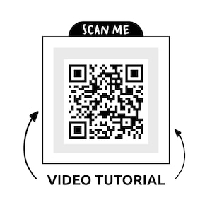 May include: A white square with a QR code in the center, framed by a thin black border. Above the square is a black banner with the text "SCAN ME." Below the square, the words "VIDEO TUTORIAL" are printed in black. Curved arrows point towards the square.