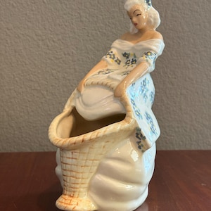 Könnte beinhalten: Ein Set aus drei Keramikbechern mit gesprenkelter, matter Oberfläche. Die Becher sind in Creme-, Hellgrau- und Dunkelgrautönen gehalten. Jeder Becher hat ein schlichtes, modernes Design und einen abgerundeten Griff.