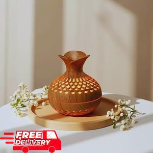 May include: A decorative wooden essential oil diffuser with a flower-shaped top and a round base. The diffuser has a wood grain pattern and a series of small, illuminated cutouts. It sits on a wooden tray, with white flowers around it.