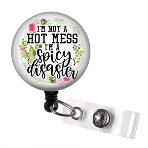 May include: A white round badge holder with a floral design and the text "I'm not a hot mess I'm a spicy disaster".