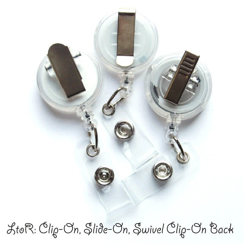 May include: Three clear plastic retractable badge holders with different attachment styles. From left to right: a clip-on, a slide-on, and a swivel clip-on.