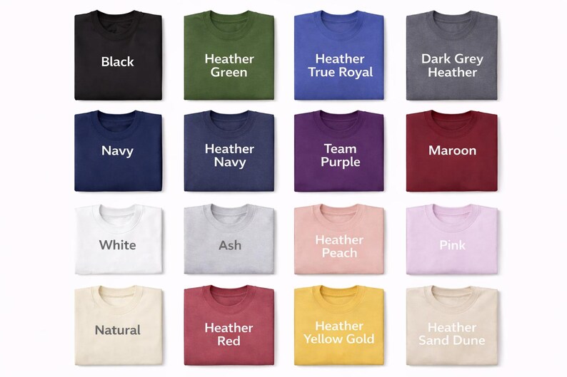 May include: A grid of sixteen folded t-shirts in various colors, each labeled with its color name in white or dark text. The colors include black, heather green, heather true royal, dark grey heather, navy, heather navy, team purple, maroon, white, ash, heather peach, pink, natural, heather red, heather yellow gold, and heather sand dune.