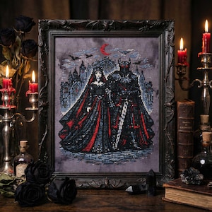 Può includere: Opera d'arte a punto croce incorniciata con una coppia gotica in abiti neri e rossi, in piedi davanti a un castello sotto una luna crescente. L'opera è esposta in una cornice scura e ornata, con candele e libri antichi sullo sfondo.