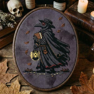 May include: Oval cross-stitch embroidery featuring a plague doctor in a black cloak and hat, holding a lantern and a book. The design includes autumn leaves and is set in a wooden hoop. The color palette is dark with shades of gray, black, and brown.