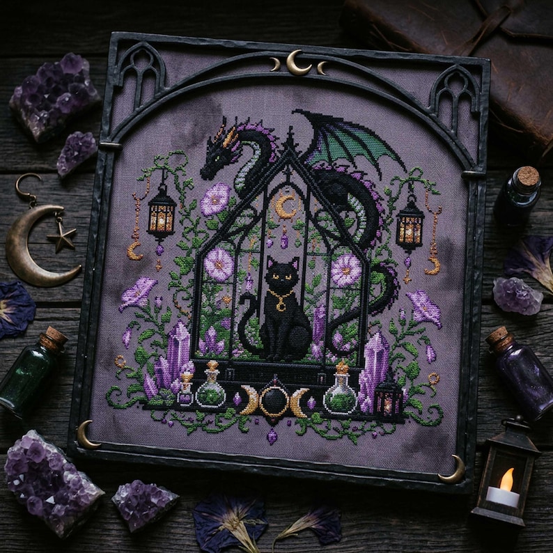 magical fantasy cross-stitch pattern featuring a black cat sitting inside a gothic greenhouse while a dark dragon with green wings curls protectively around the roof. The scene is decorated with lavender flowers, leafy vines, purple crystals, potion bottles, hanging lanterns, crescent moon charms, and celestial ornaments. The rich palette of black, green, lavender, gray, purple, and gold creates a mystical witchy garden mood, perfect for cat lovers, dragon fans, fantasy décor, and handmade walL