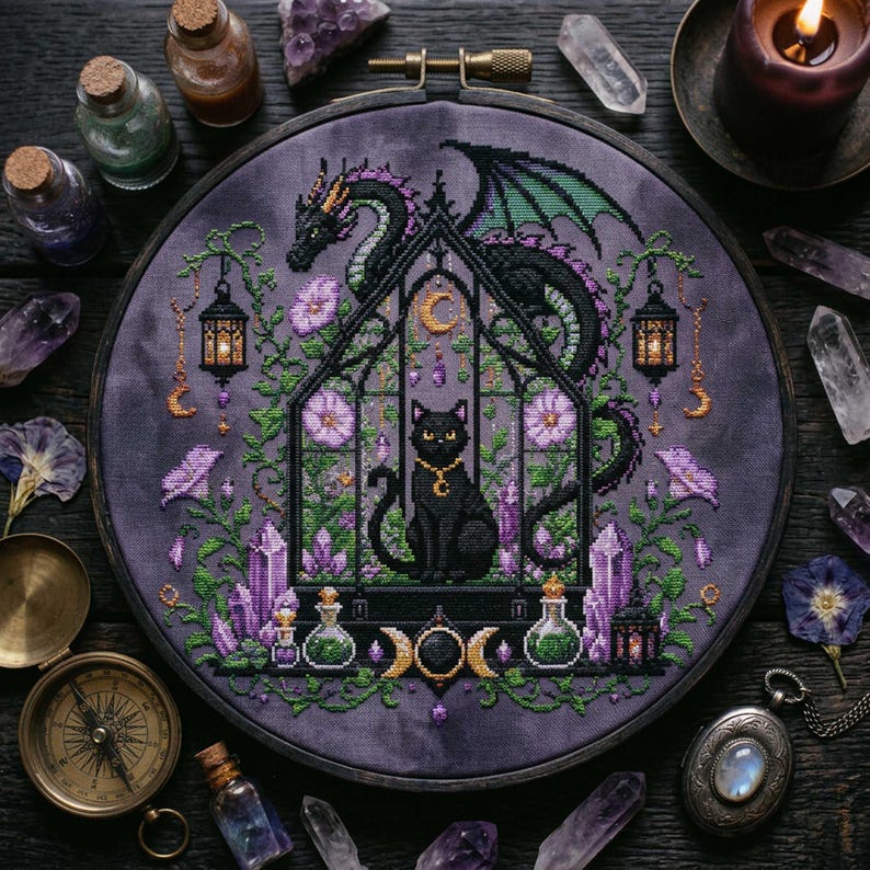 magical fantasy cross-stitch pattern featuring a black cat sitting inside a gothic greenhouse while a dark dragon with green wings curls protectively around the roof. The scene is decorated with lavender flowers, leafy vines, purple crystals, potion bottles, hanging lanterns, crescent moon charms, and celestial ornaments. The rich palette of black, green, lavender, gray, purple, and gold creates a mystical witchy garden mood, perfect for cat lovers, dragon fans, fantasy décor, and handmade walL