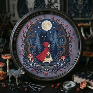 May include: A framed cross-stitch depicting Little Red Riding Hood walking through a forest at night. The scene includes a full moon, a wolf silhouette, and red mushrooms. The frame is dark wood.
