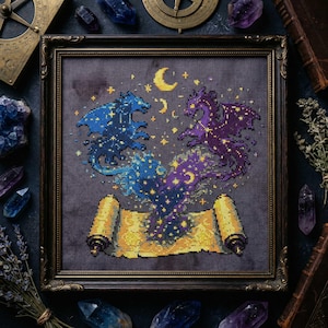 May include: Cross-stitch art featuring two dragons in blue and purple, surrounded by stars and moons. The dragons are above a yellow scroll. The artwork is framed in a dark wooden frame. The background is dark gray.