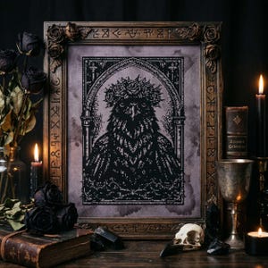 May include: Framed black and white cross-stitch art featuring a stylized bird wearing a floral crown. The artwork is displayed in a decorative wooden frame with carved details and is surrounded by gothic-themed decor, including black roses and candles.