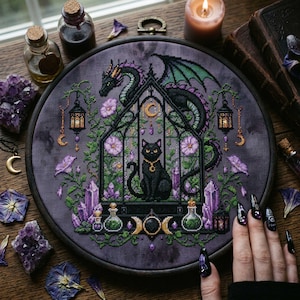 magical fantasy cross-stitch pattern featuring a black cat sitting inside a gothic greenhouse while a dark dragon with green wings curls protectively around the roof. The scene is decorated with lavender flowers, leafy vines, purple crystals, potion bottles, hanging lanterns, crescent moon charms, and celestial ornaments. The rich palette of black, green, lavender, gray, purple, and gold creates a mystical witchy garden mood, perfect for cat lovers, dragon fans, fantasy décor, and handmade walL