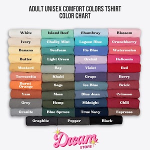 May include: A color chart for adult unisex Comfort Colors t-shirts, displaying folded fabric samples in various shades. The text reads: ADULT UNISEX COMFORT COLORS TSHIRT COLOR CHART, with labels for each color including White, Ivory, Banana, Butter, Mustard, Terracotta, Burnt Orange, Yam, Grey, Granite, Graphite, Pepper, and Black.