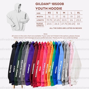Puede incluir: Exhibici&oacute;n de sudaderas con capucha juveniles en varios colores, como negro, azul marino y rojo. La imagen incluye una tabla de tallas con medidas en pulgadas y el texto "GILDAN 18500B YOUTH HOODIE". Las sudaderas se muestran en perchas.