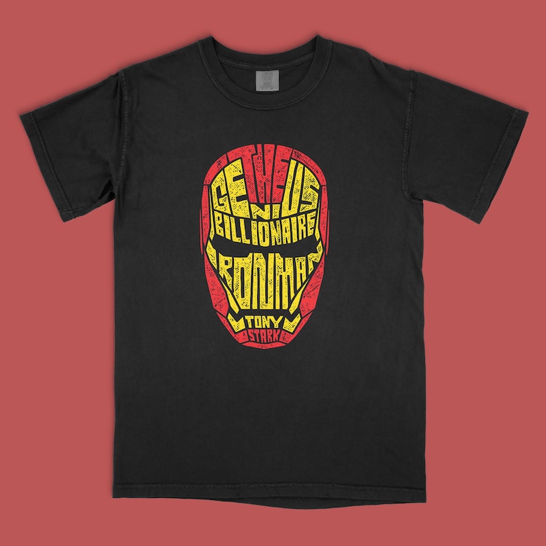 May include: A black short-sleeve t-shirt featuring a graphic of a helmet shape formed by yellow text on a red background. The text reads: THE GENIUS BILLIONAIRE IRON MAN TONY STARK. The graphic has a distressed, weathered texture throughout the design.