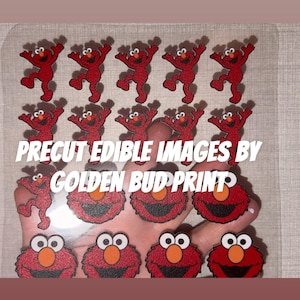 May include: A sheet of precut edible images featuring red Elmo characters in two designs: full-body dancing figures and close-up faces. The text PRECUT EDIBLE IMAGES BY GOLDEN BUD PRINT is printed in white across the center of the clear plastic sheet.