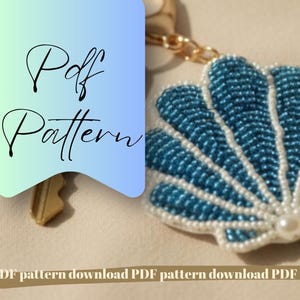 May include: A beaded seashell keychain with a blue and white design. The keychain has a gold chain and a pearl at the center. The image also includes the text "Pdf Pattern".