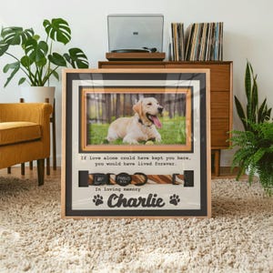 May include: A rectangular wooden memorial frame featuring a photograph of a yellow Labrador retriever, a brown patterned dog collar with a black tag, and the text: If love alone could have kept you here, you would have lived forever. In loving memory Charlie.