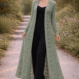 Pode incluir: Uma caneca de cerâmica branca com uma alça preta e o texto "But First, Coffee" em estilo manuscrito. A caneca está sobre uma superfície branca. A caneca tem aproximadamente 10 cm de altura.