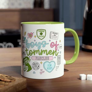 May include: White ceramic mug with a green interior and handle, decorated with the words "boys of tommen fanclub" in a whimsical font. The mug features various illustrations, including a heart, a jersey, and a CD.