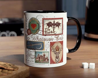 Może przedstawiać: Biały ceramiczny kubek z czarnym uchwytem i obramowaniem, ozdobiony wzorami znaczków pocztowych w stylu vintage. Znaczki przedstawiają serce, smoka, jelenia i zamek z napisem "The Thirteen" i "To Whatever End."