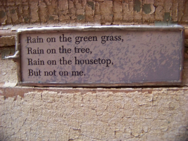 Puede incluir: Un poema enmarcado con el texto "Rain on the green grass, Rain on the tree, Rain on the housetop, But not on me."