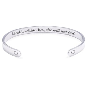 May include: A silver cuff bracelet with the engraved words "God is within her, she will not fail." Small heart shapes are at each open end. The bracelet is shown on a white background.