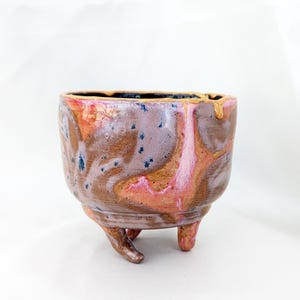 Sculptural stoneware trinket dish with tentacle-like feet, pink and gold marbled glaze, kintsugi