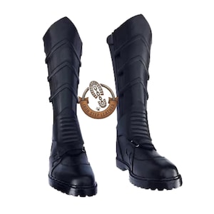 Peut inclure: Deux bottes noires en cuir jusqu'aux genoux. Les bottes présentent un motif texturé sur la tige supérieure et une fermeture à boucle près de la cheville. Les semelles sont épaisses et robustes. Les bottes sont présentées sur fond blanc.