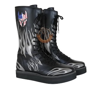 Könnte beinhalten: Schwarze Lederstiefel mit Plateausohle und silbernem Flammendesign. Die Stiefel haben eine Totenkopf-Grafik mit amerikanischem Flaggen-Design und Schnürverschluss. Der Text "IRON STEP LEATHER" ist sichtbar.