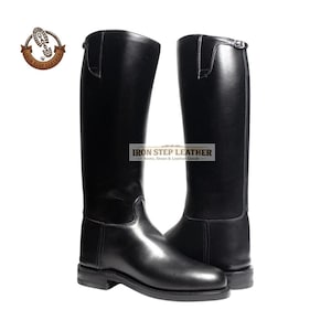 May include: A pair of tall, black leather riding boots. The boots have a smooth, glossy finish and a classic design. The boots feature a buckle at the top and are labeled "Iron Step Leather".