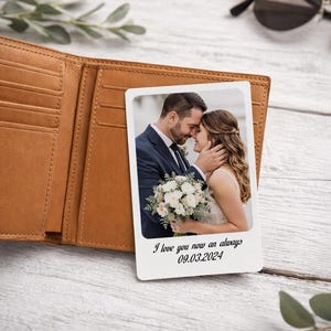May include: A tan leather wallet with a white photo card featuring a couple embracing. The card has the text "I love you now an always 09.03.2024". The wallet is open, revealing card slots.