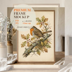 May include: Framed artwork featuring a detailed illustration of a robin perched on a branch with leaves and berries. The artwork is in a wooden frame. The image includes the text "PREMIUM FRAME MOCKUP" and other details.