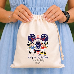 Può includere: Una sacca color crema con coulisse con Topolino e Minni in abiti da crociera. La sacca presenta la scritta "Let's Cruise Family Trip 2026" e un design nautico con i numeri "20 26".
