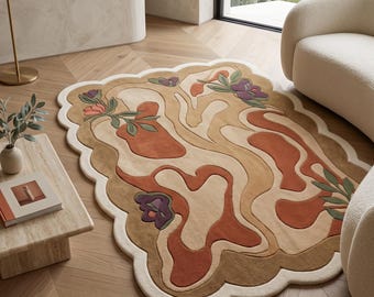 Peut inclure: Un tapis à bord festonné présentant un motif abstrait et ondulé dans des tons de beige, de brun clair et de terre cuite. Le design comprend des motifs floraux stylisés avec des pétales violets et roses et des feuilles vertes sur une bordure crème.