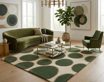 Peut inclure: Un ensemble de salon comprenant un canapé incurvé en velours vert olive, un fauteuil assorti vert olive et un tapis rectangulaire à fond crème avec de grands motifs circulaires vert foncé. Une table basse en verre à deux niveaux est au centre.